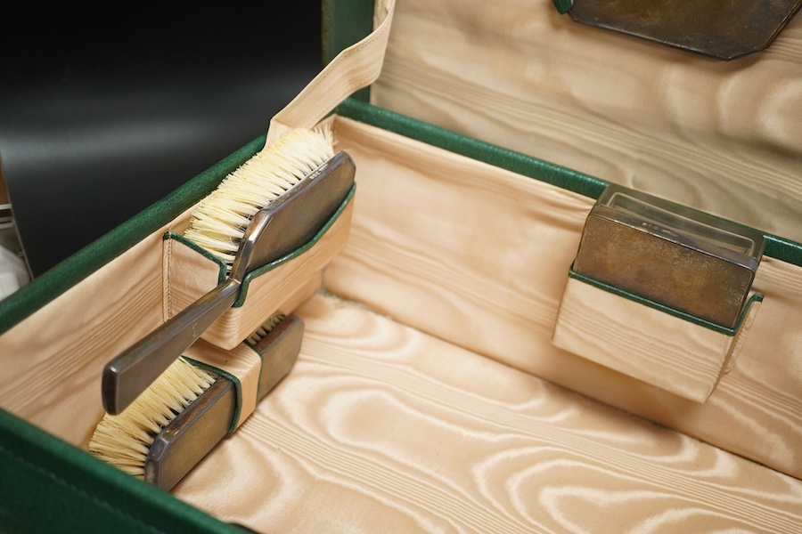 Two fitted travelling vanity cases, one with eight silver mounted toilet jars etc. by Asprey & Co, London, 1938, the other with seventeen silver mounted items, Thomas Jones Watson, London, 1911(incomplete).